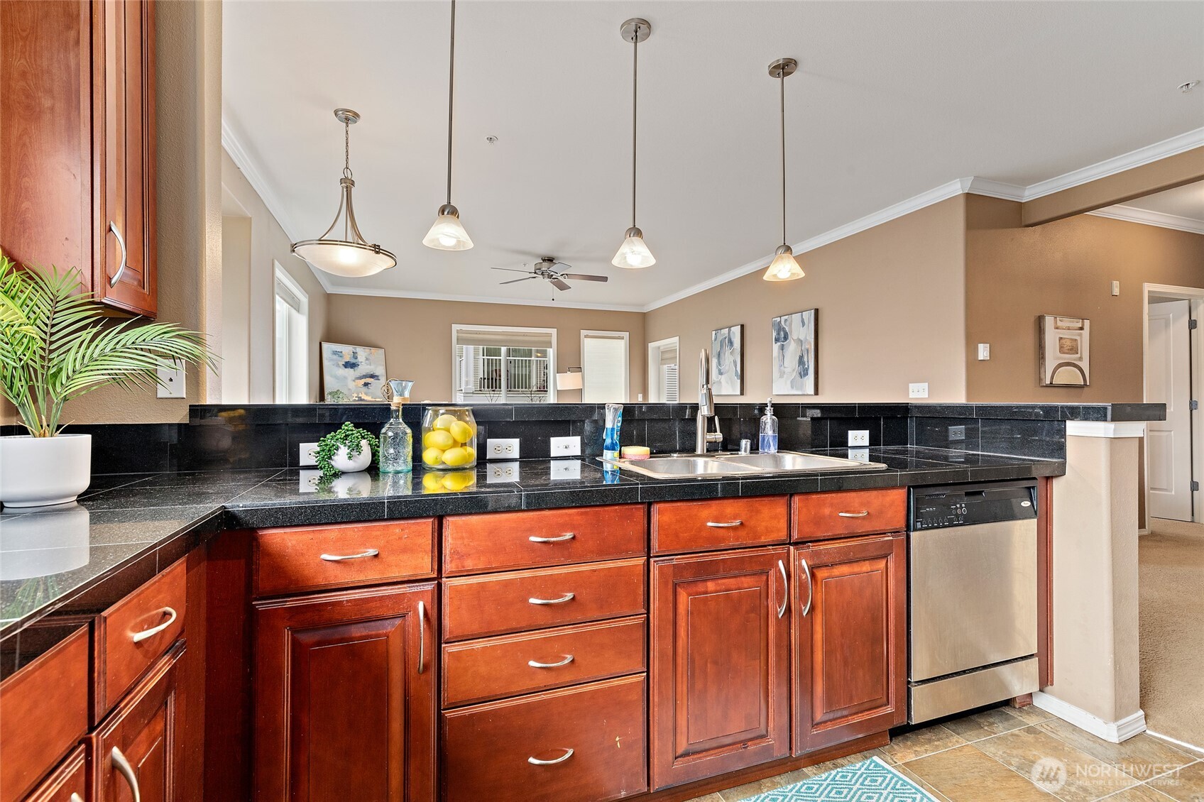 14915 38th Drive Southeast, Unit 2049 Bothell, WA 98012 - Photo 11 of 36 a kitchen with stainless steel appliances granite countertop a sink a counter space and a view of living room