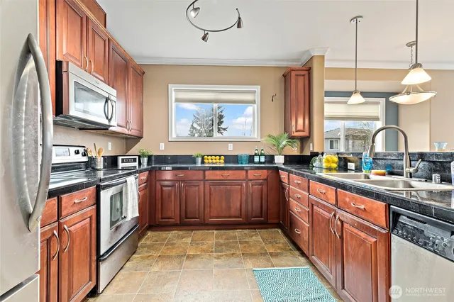 a kitchen with stainless steel appliances granite countertop a stove a sink and a microwave