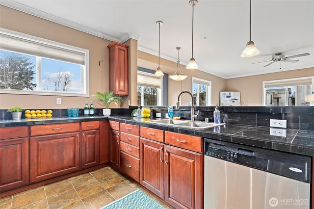 a large kitchen with stainless steel appliances granite countertop a sink and wooden cabinets