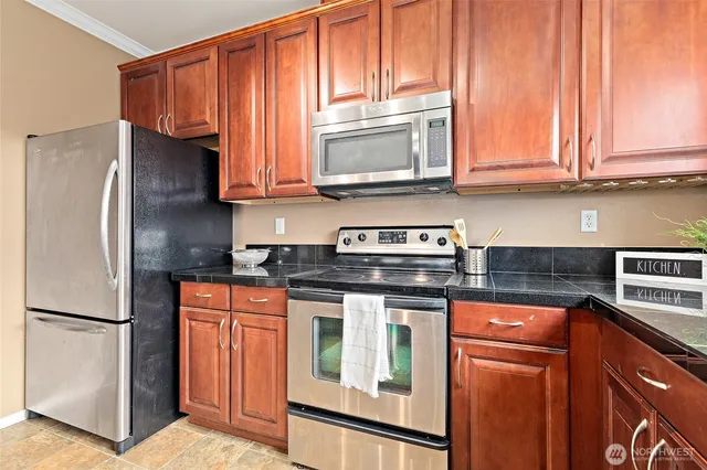 a kitchen with stainless steel appliances granite countertop a refrigerator stove top oven and sink