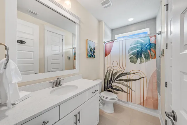 a outdoor kitchen with stainless steel appliances kitchen island granite countertop a dining table chairs and a living room view