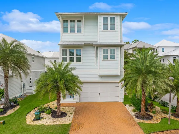 a palm tree sitting in front of a house with a yard