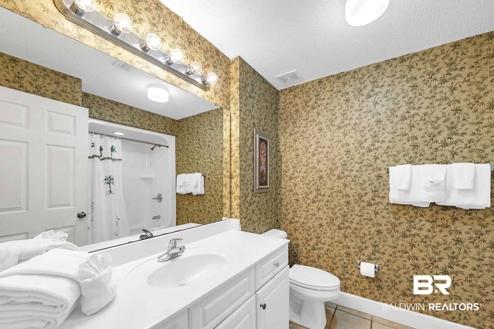 27580 Canal Road, Unit 1214 AND BOAT SLIP #62 Orange Beach, AL 36561 - Photo 36 of 67 Full bath featuring vanity, tile patterned flooring, a textured ceiling, a shower with curtain, and toilet