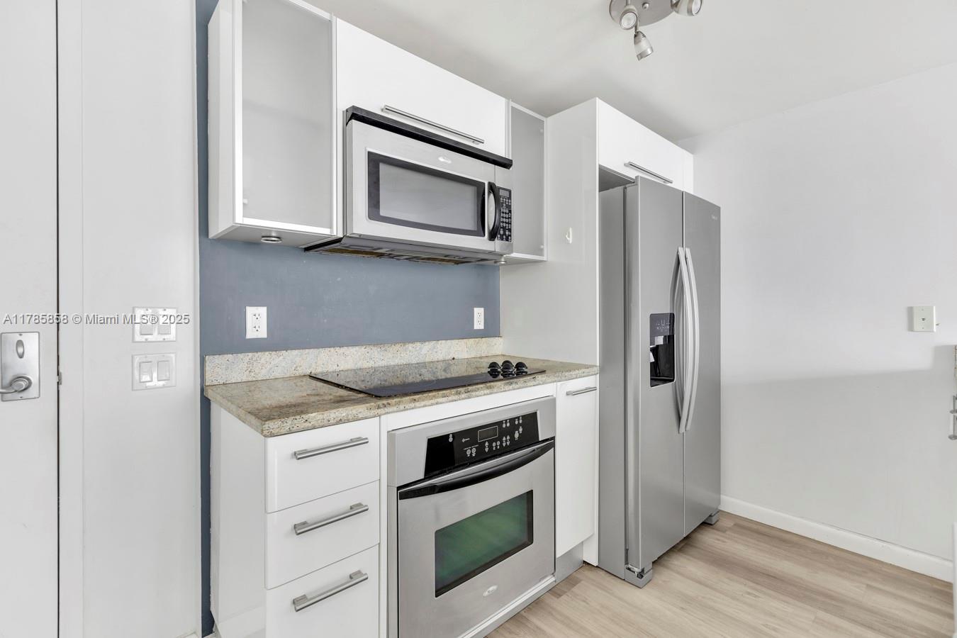 185 Southwest 7th Street, Unit 1508 Miami, FL 33130 - Photo 3 of 30 a kitchen with a stove microwave and refrigerator