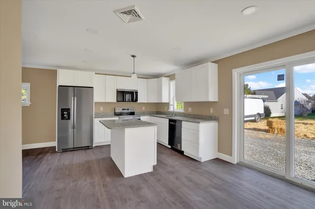 a kitchen with cabinets and wooden floor
