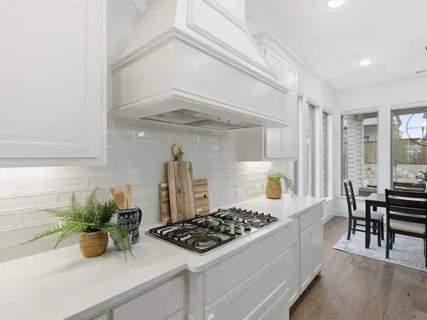 a kitchen with a sink a stove and chairs