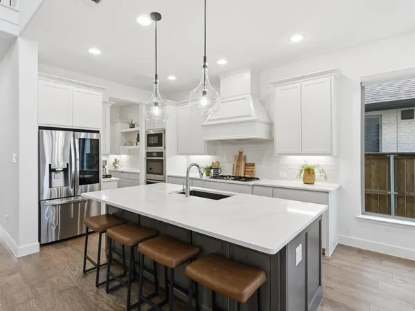 a kitchen with a stove a refrigerator and a wooden floor