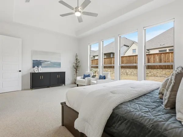 a spacious bedroom with a large bed and a chandelier