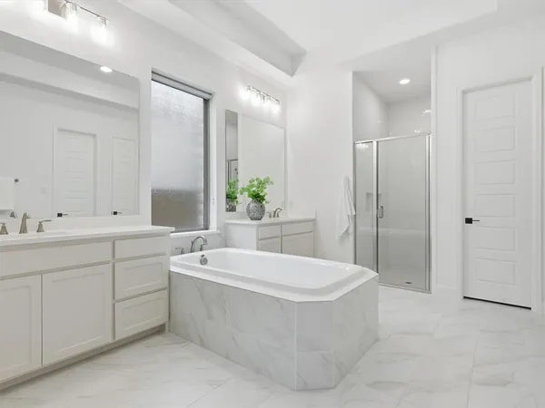 a spacious bathroom with a tub sink and mirror