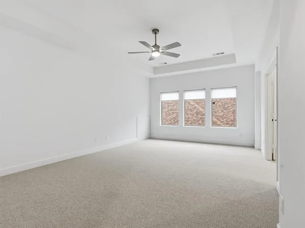 an empty room with a window and a ceiling fan