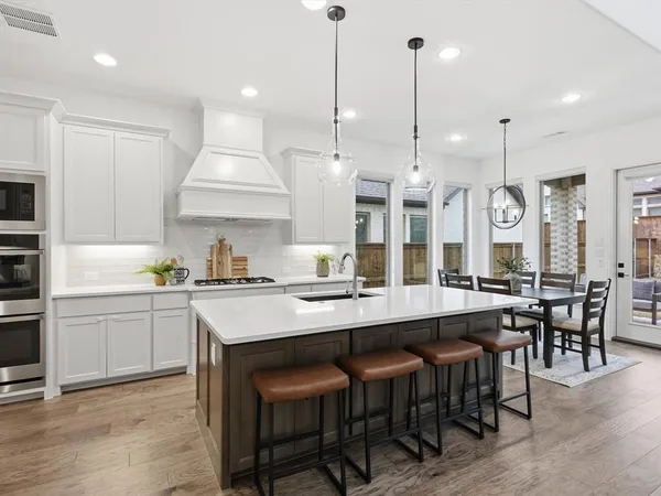 a large kitchen with a table and chairs