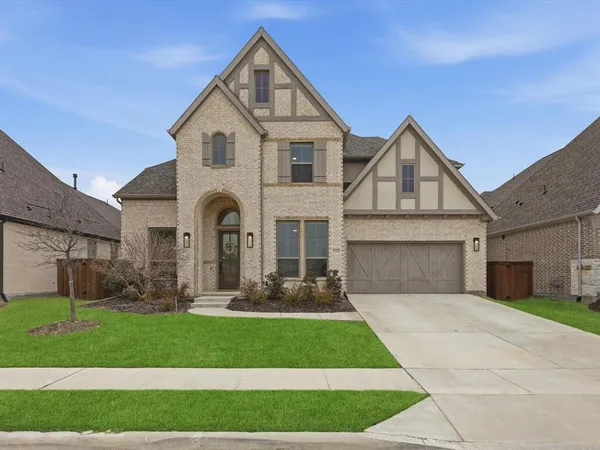 a front view of a house with a garden and yard