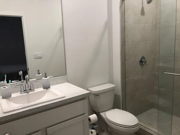 a bathroom with a sink a toilet and shower