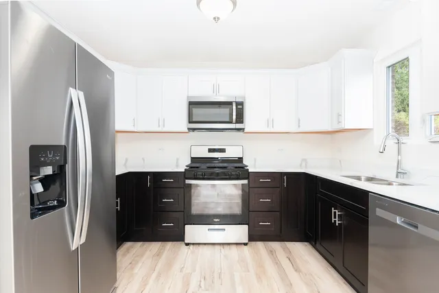 a kitchen with stainless steel appliances granite countertop a refrigerator and a stove top oven