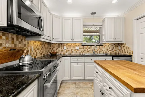 a kitchen with stainless steel appliances granite countertop a sink stove and cabinets