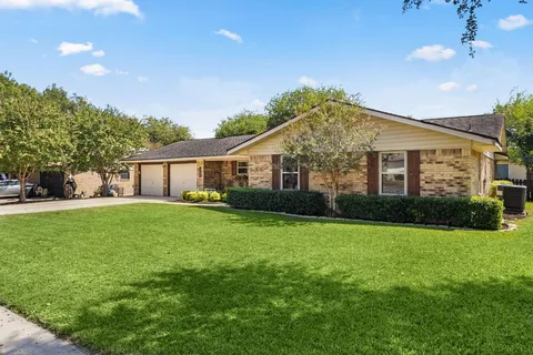 a front view of a house with a yard and trees