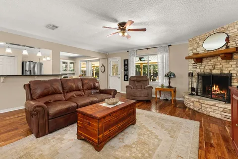 a living room with furniture a fireplace and a large window