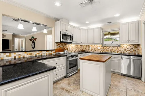 a kitchen with stainless steel appliances granite countertop a refrigerator and microwave