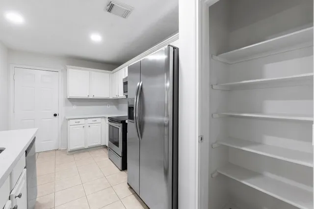 a kitchen with cabinets and stainless steel appliances