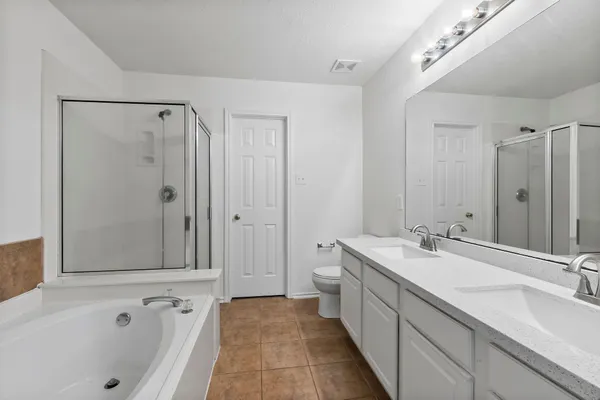 a spacious bathroom with a tub sink and mirror