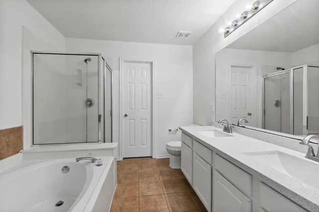 a spacious bathroom with a tub sink and mirror