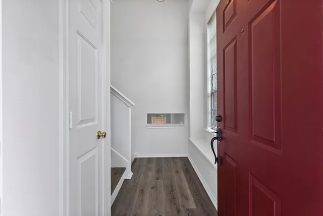 a view of a hallway with wooden floor and closet