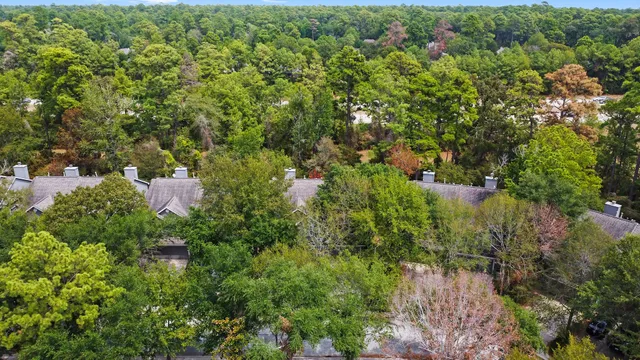 an aerial view of residential house with outdoor space and trees all around