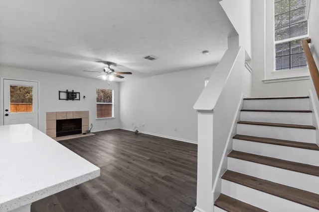 a view of a livingroom with wooden floor and a fireplace