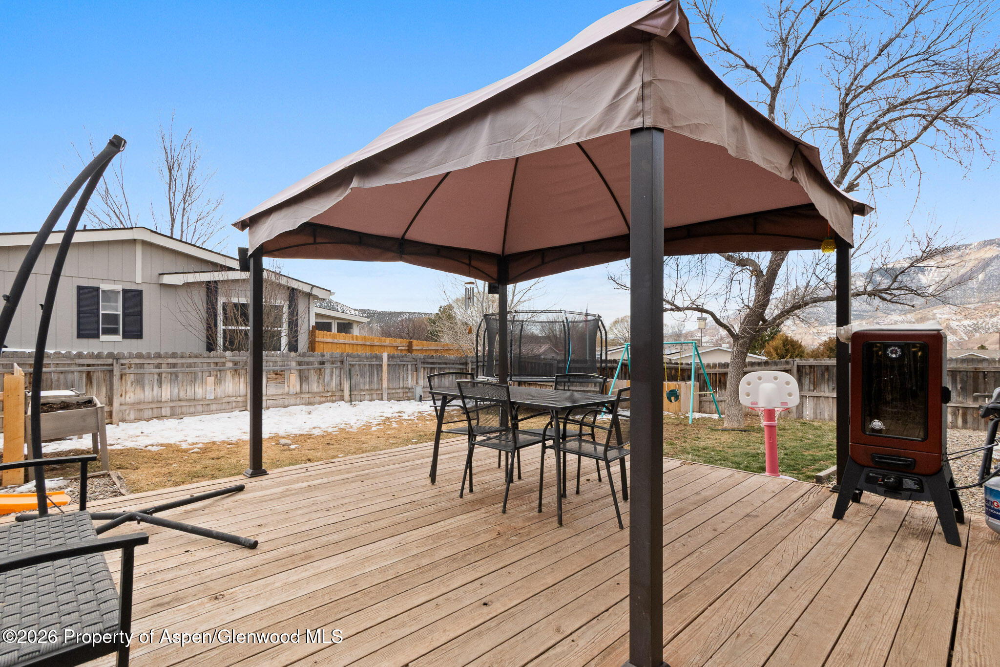 106 Cedar Circle Parachute, CO 81635 - Photo 30 of 35 a view of a roof deck with table and chairs under an umbrella with wooden floor