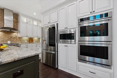 a kitchen with white cabinets and white appliances