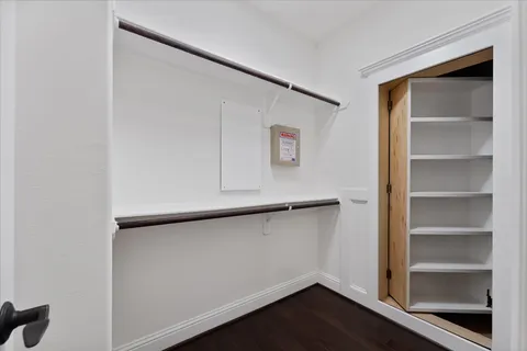 a spacious bedroom with a bed and wooden floor