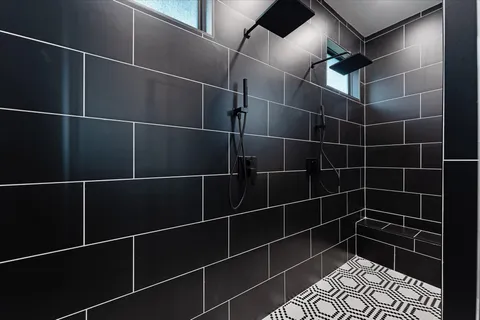 a bathroom with a double vanity sink a mirror and a shower