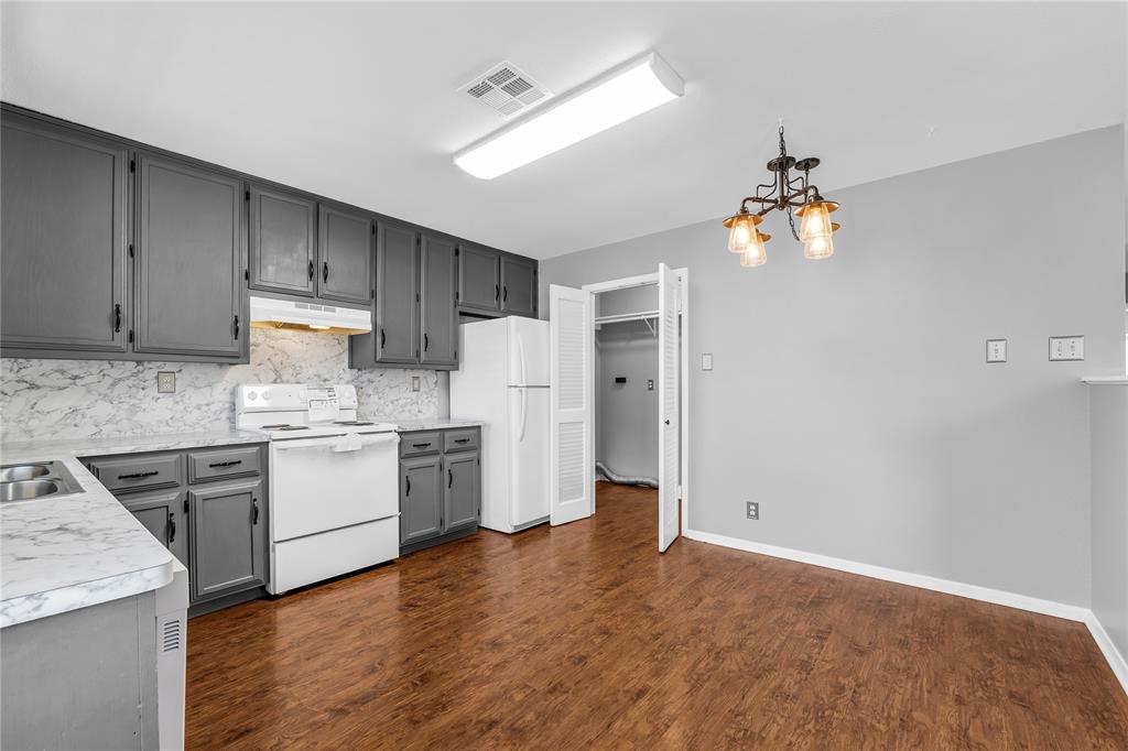 1409 Chapel Downs Waco, TX 76712 - Photo 6 of 20 a kitchen with granite countertop a refrigerator a stove top oven a sink and dishwasher