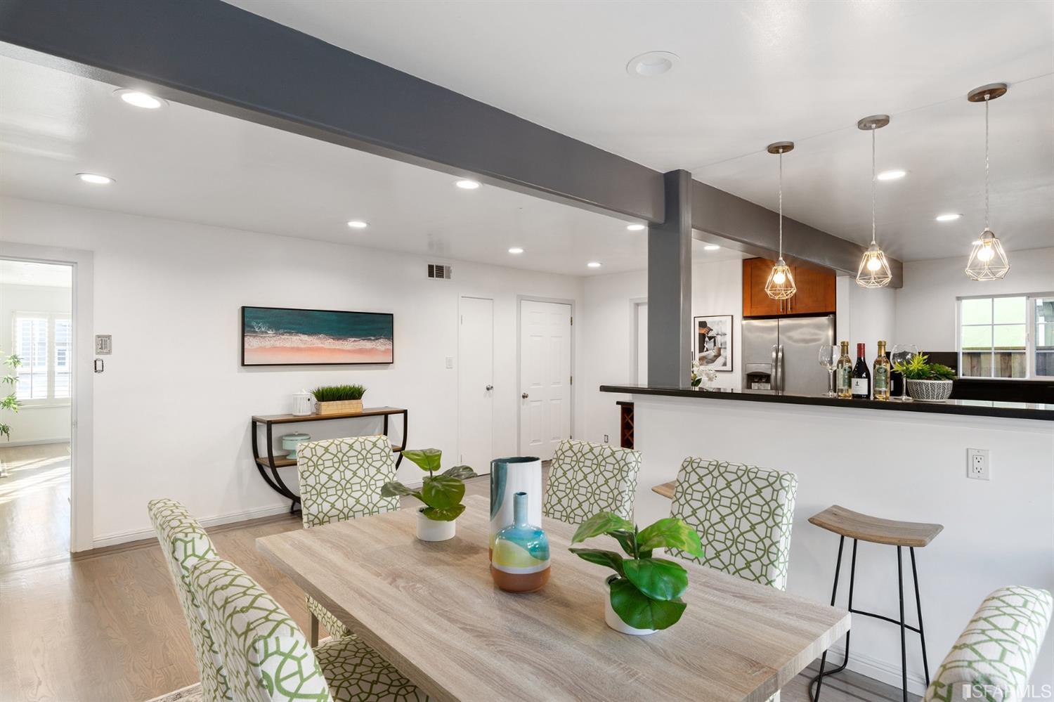 171 Beachview Avenue Pacifica, CA 94044 - Photo 19 of 52 a kitchen with stainless steel appliances granite countertop wooden floor a stove top oven a dining table and chairs with wooden floor