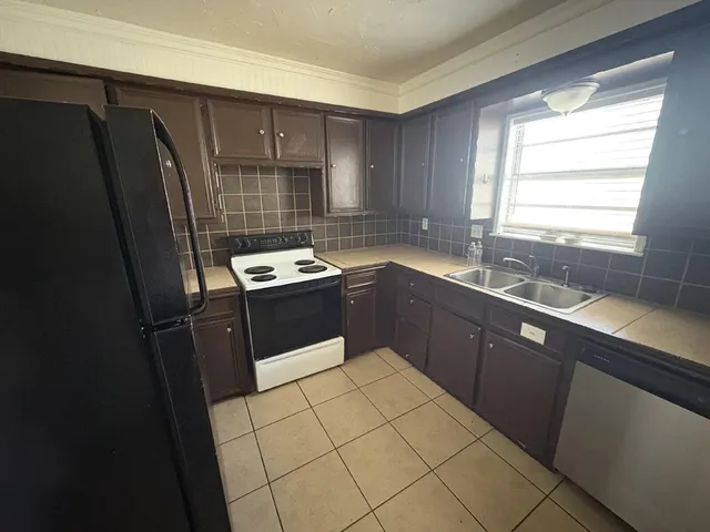a kitchen with a sink a refrigerator and window