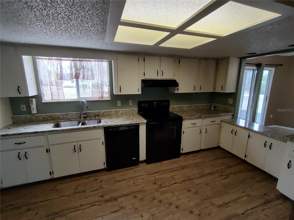8792 Southwest 116th Place Road Ocala, FL 34481 - Photo 4 of 6 a kitchen with granite countertop a sink cabinets stainless steel appliances and a window