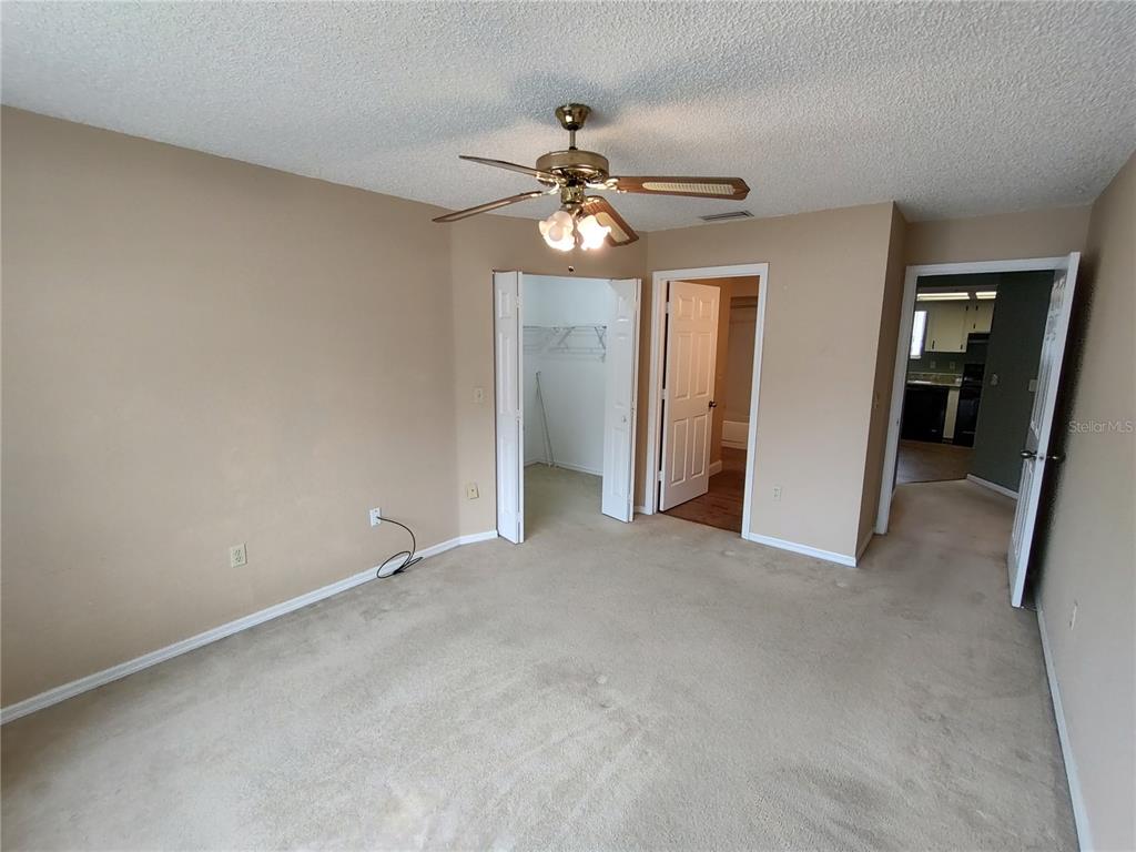 8792 Southwest 116th Place Road Ocala, FL 34481 - Photo 5 of 6 an empty room with closet and a chandelier fan