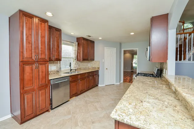 a kitchen with stainless steel appliances granite countertop a sink stove and cabinets