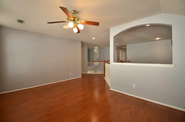 a view of an empty room with wooden floor