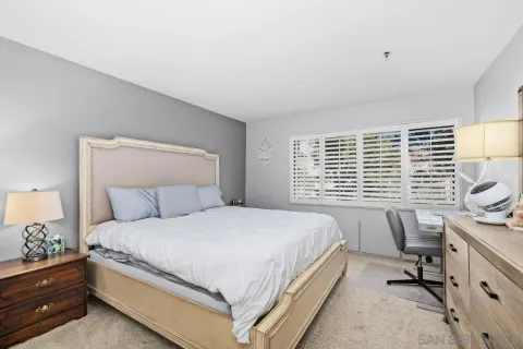 a bedroom with a bed and a lamp on dresser