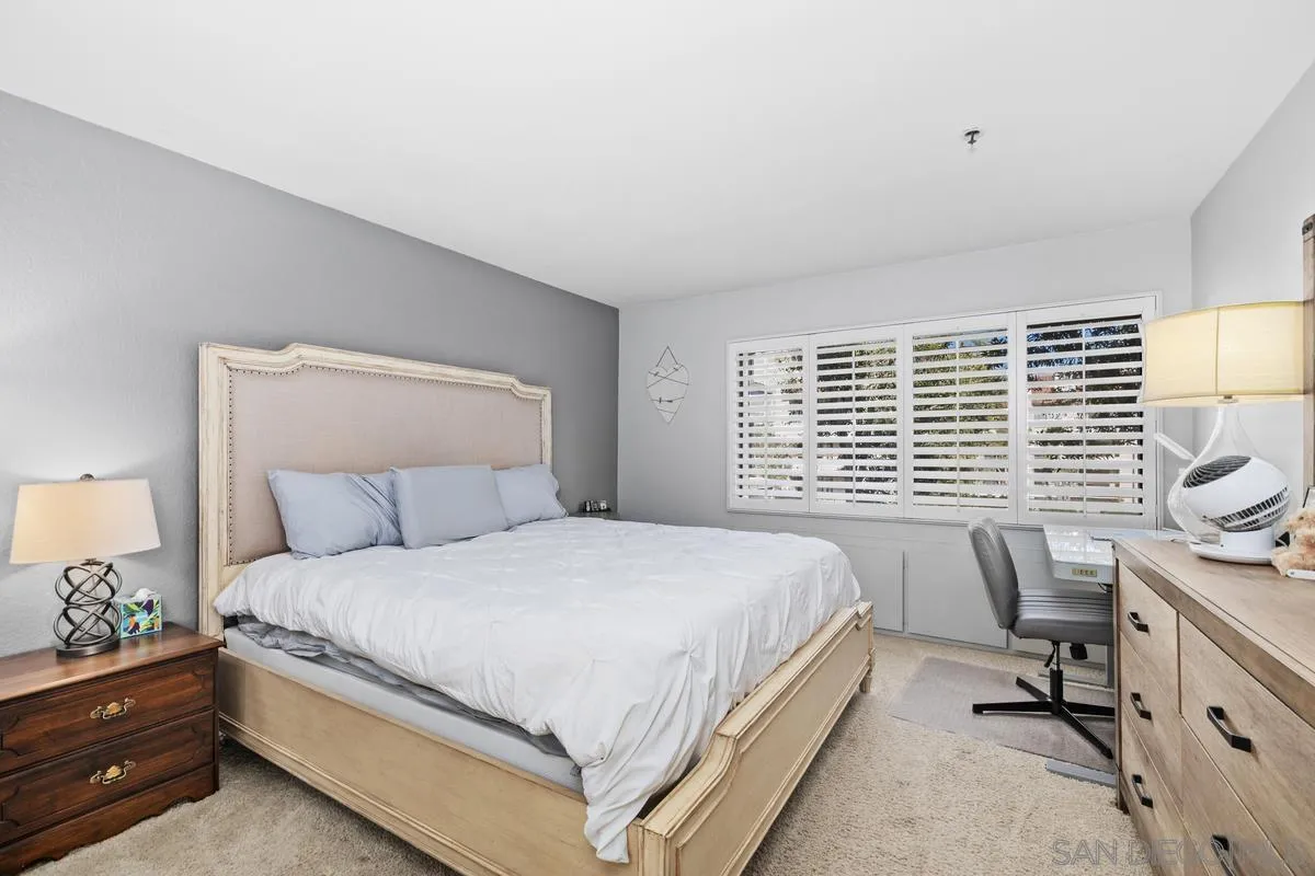 5605 Friars Road, Unit 308 San Diego, CA 92110 - Photo 14 of 39 a bedroom with a bed and a lamp on dresser