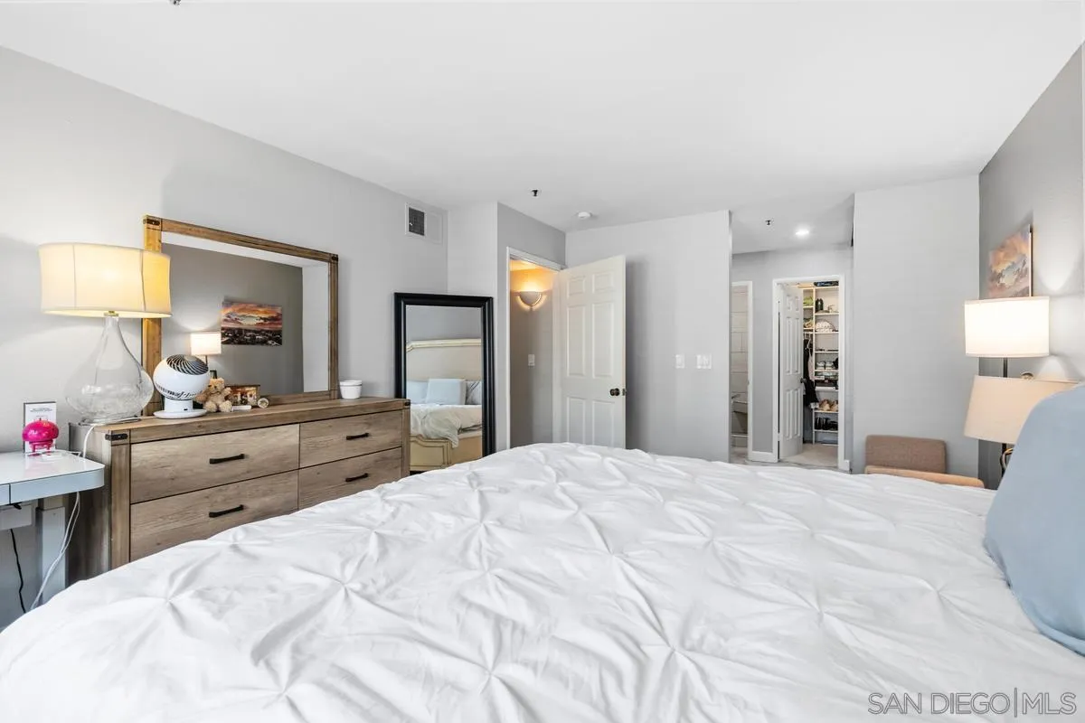 5605 Friars Road, Unit 308 San Diego, CA 92110 - Photo 16 of 39 a bedroom with a bed and a large mirror