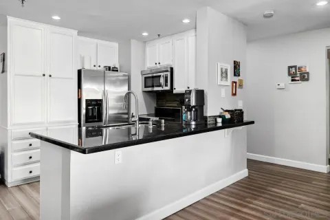 a kitchen with granite countertop a refrigerator and a stove top oven