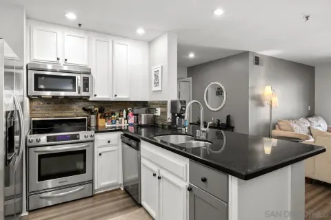 a kitchen with kitchen island granite countertop a sink and stove top oven