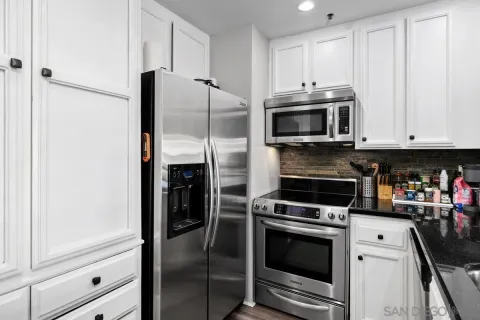 a kitchen with stainless steel appliances white cabinets and a stove