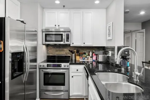a kitchen with stainless steel appliances granite countertop a stove a microwave and a refrigerator