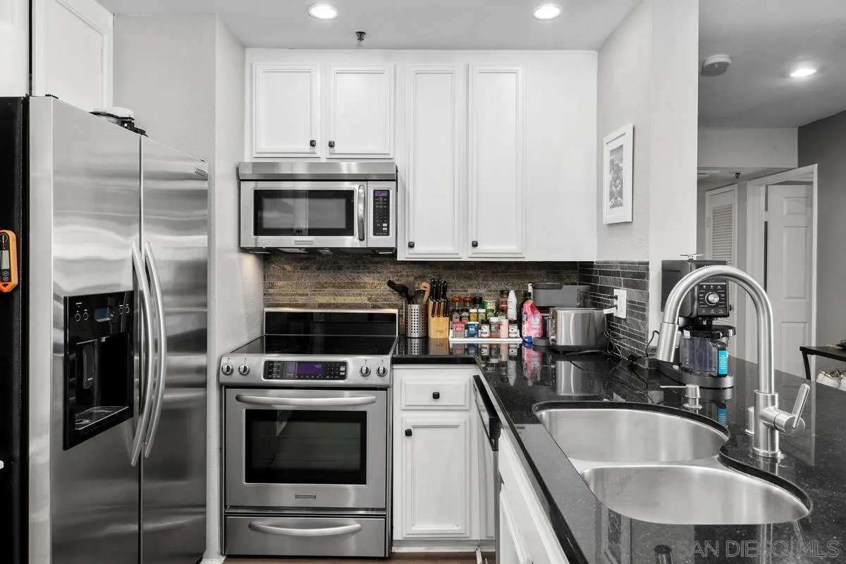5605 Friars Road, Unit 308 San Diego, CA 92110 - Photo 6 of 39 a kitchen with stainless steel appliances granite countertop a stove a microwave and a refrigerator