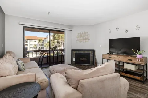 a living room with furniture a flat screen tv and a fireplace