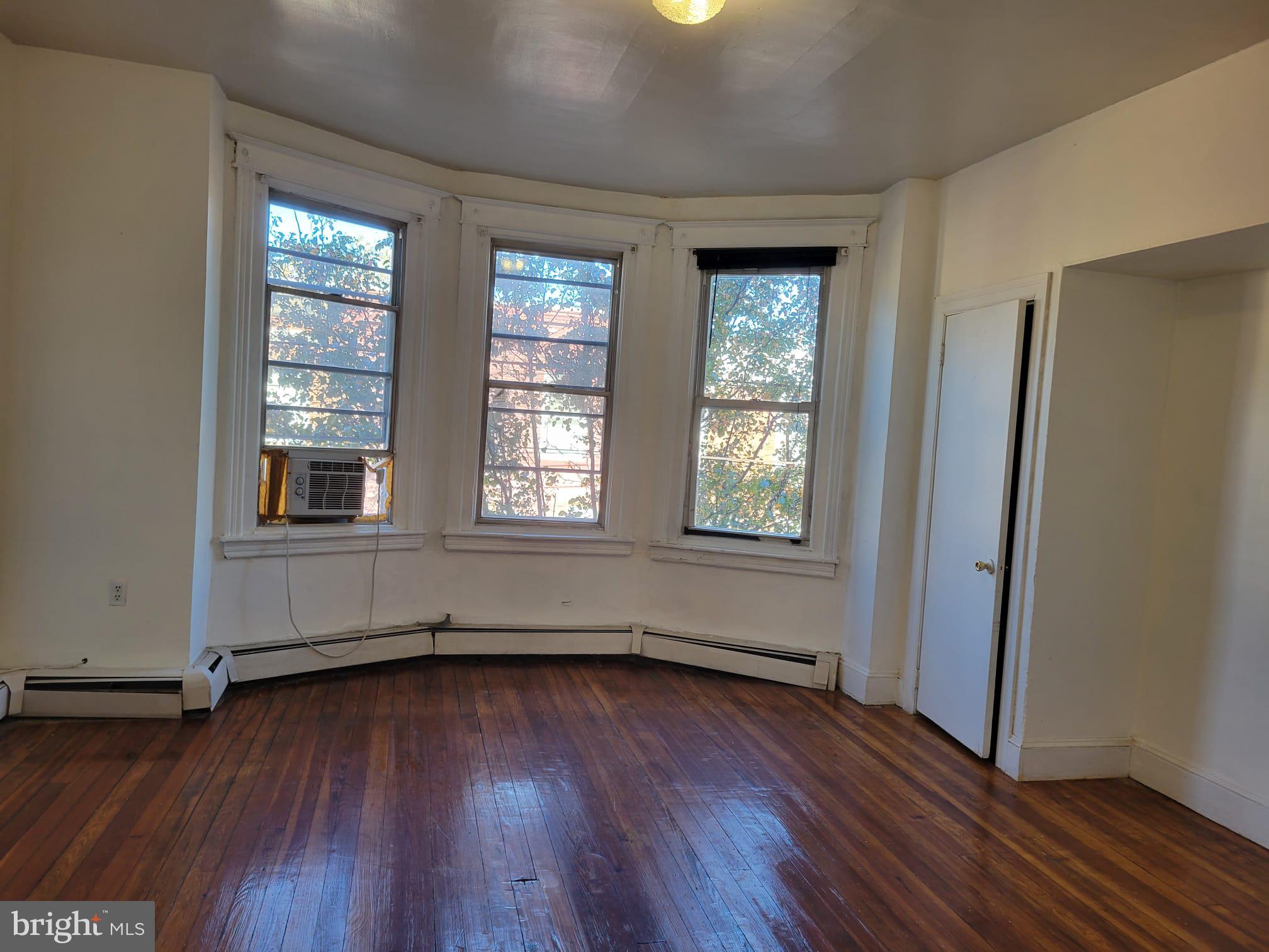 616 Tasker Street, Unit 2 Philadelphia, PA 19148 - Photo 6 of 22 an empty room with wooden floor and windows