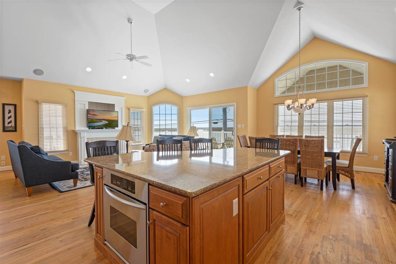 5441 Ocean Drive Avalon, NJ 08202 - Photo 12 of 26 an open kitchen with granite countertop a stove and a table chairs